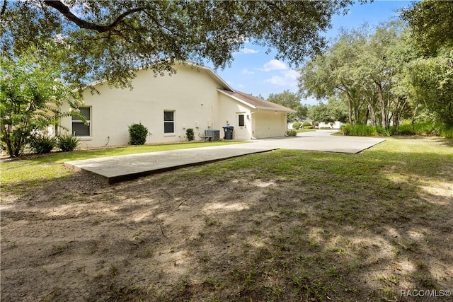 5799 N Oakmont Dr, Beverly Hills, FL 34465 - rear view of house featuring stucco siding and a lawn