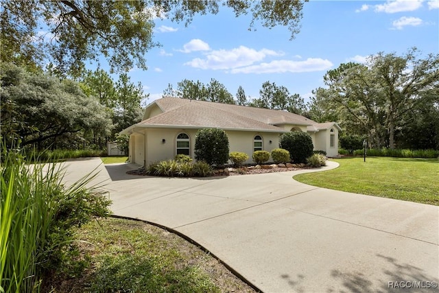 5799 N Oakmont Dr, Beverly Hills, FL 34465 - view of front of property with concrete driveway, an attached garage, stucco siding, and a front lawn