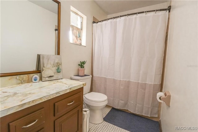 bathroom featuring toilet, vanity, a shower with shower curtain, and tile patterned flooring