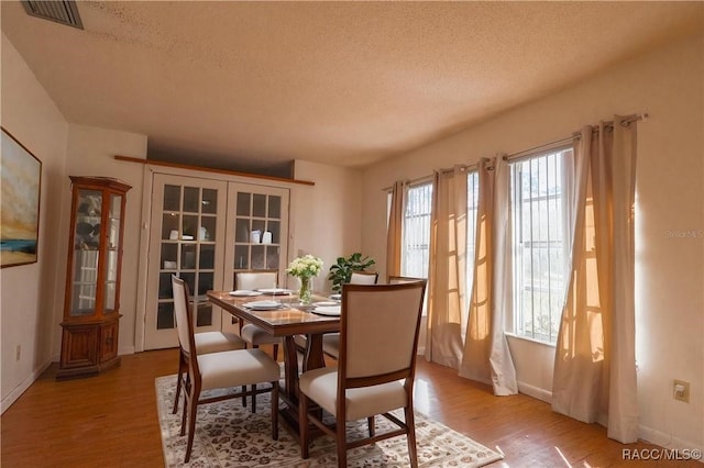 dining space featuring a textured ceiling and light wood-type flooring