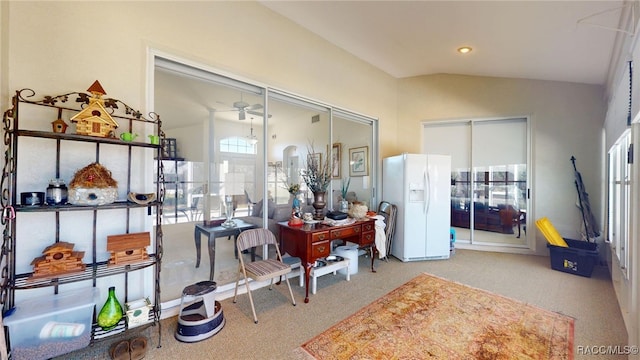 interior space featuring lofted ceiling, light carpet, and a ceiling fan