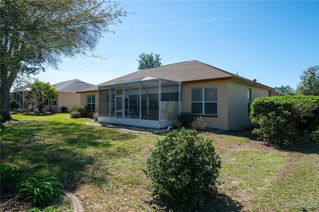 back of house with a yard, a lanai, and stucco siding