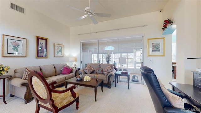 living area featuring a ceiling fan, visible vents, and light colored carpet