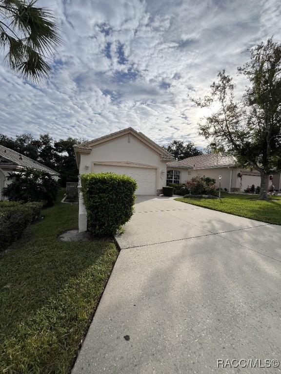 single story home featuring a front yard and a garage