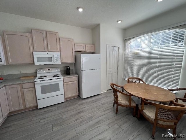 kitchen featuring white appliances, light hardwood / wood-style floors, and light brown cabinetry