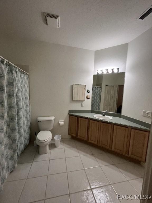 bathroom featuring toilet, tile patterned flooring, and vanity