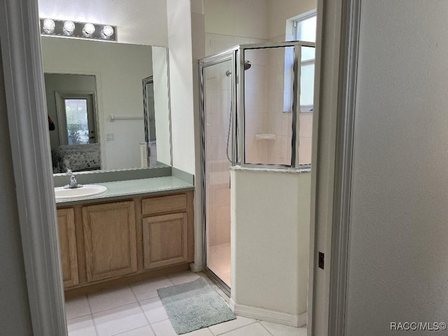 bathroom featuring a shower with door, tile patterned flooring, a wealth of natural light, and vanity