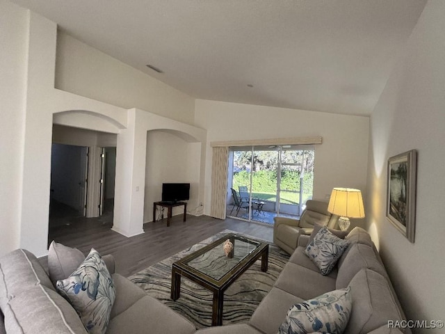 living room featuring lofted ceiling and dark hardwood / wood-style floors