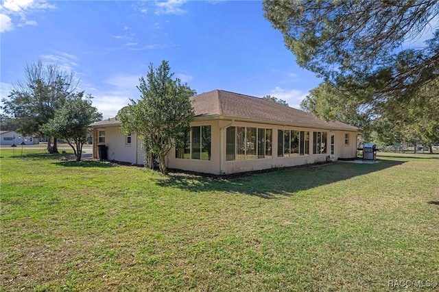 rear view of property featuring a lawn