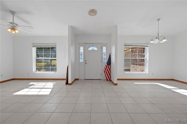 tiled foyer with ceiling fan with notable chandelier