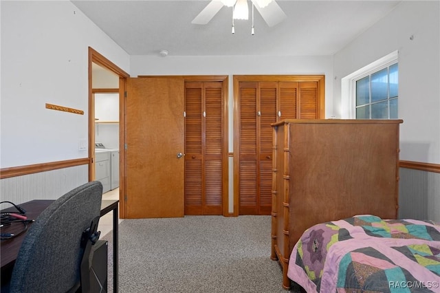 carpeted bedroom featuring washing machine and clothes dryer, ceiling fan, and two closets