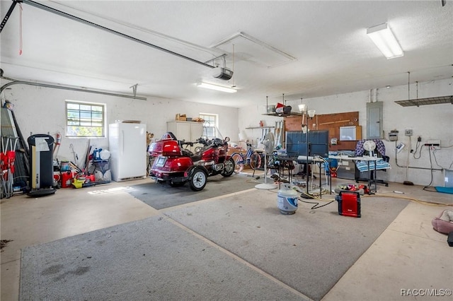 garage with electric panel, white refrigerator, and a garage door opener