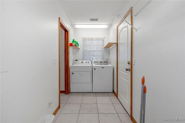 washroom featuring light tile patterned flooring and washer and dryer