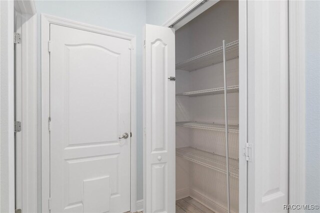 bedroom with a tray ceiling, dark wood-type flooring, and ornamental molding