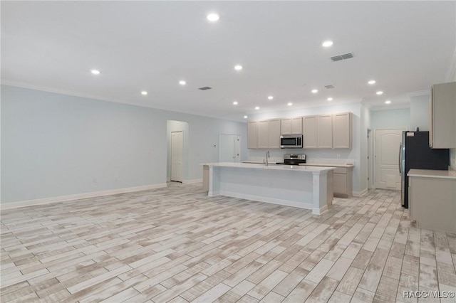 kitchen featuring light countertops, visible vents, a kitchen island with sink, and appliances with stainless steel finishes