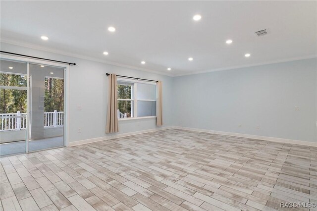 kitchen with light hardwood / wood-style floors, a breakfast bar area, a kitchen island with sink, appliances with stainless steel finishes, and ornamental molding