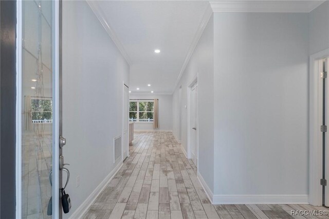 foyer entrance featuring light hardwood / wood-style floors and crown molding