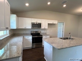 kitchen with white cabinetry, sink, lofted ceiling, a kitchen island, and appliances with stainless steel finishes