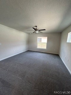 empty room featuring ceiling fan, dark carpet, and a textured ceiling