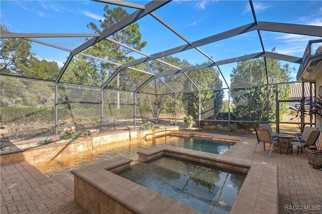 view of pool featuring a lanai, a patio area, and an in ground hot tub