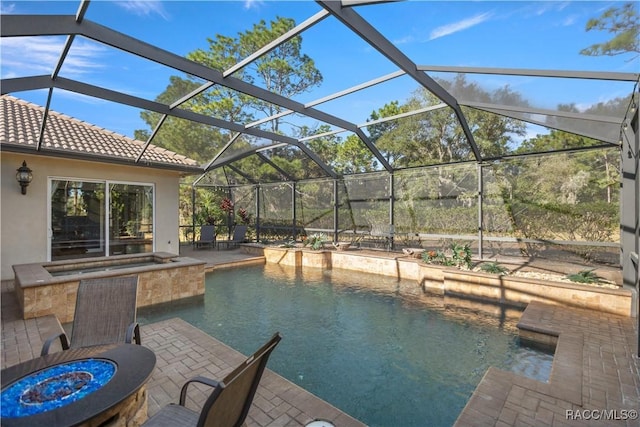 view of pool with a lanai, a fire pit, an in ground hot tub, and a patio