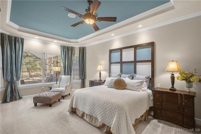 carpeted bedroom featuring a tray ceiling, ceiling fan, and crown molding