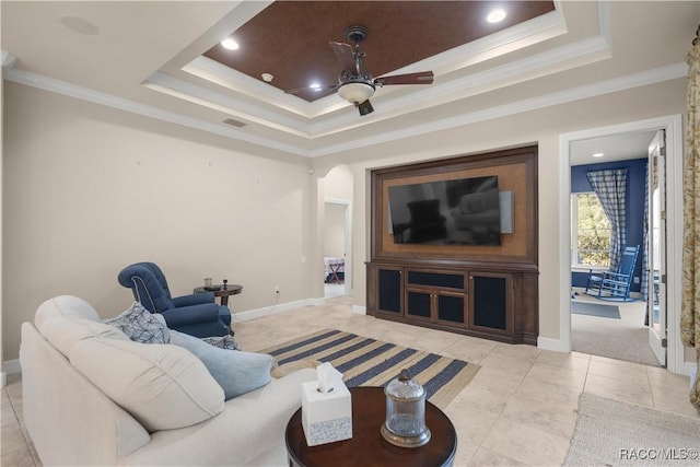 tiled living room with a tray ceiling, ceiling fan, and crown molding