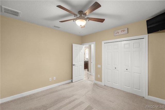 unfurnished bedroom with a closet, ceiling fan, and light colored carpet