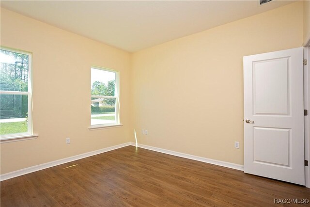 unfurnished bedroom featuring a raised ceiling, ornamental molding, a walk in closet, and light hardwood / wood-style flooring