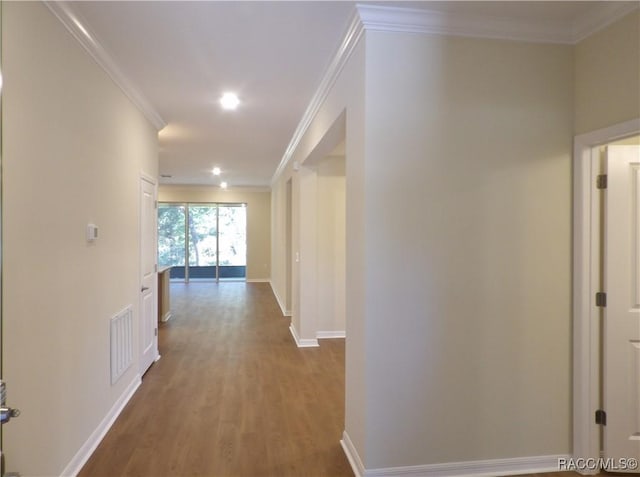 hall with wood-type flooring and ornamental molding