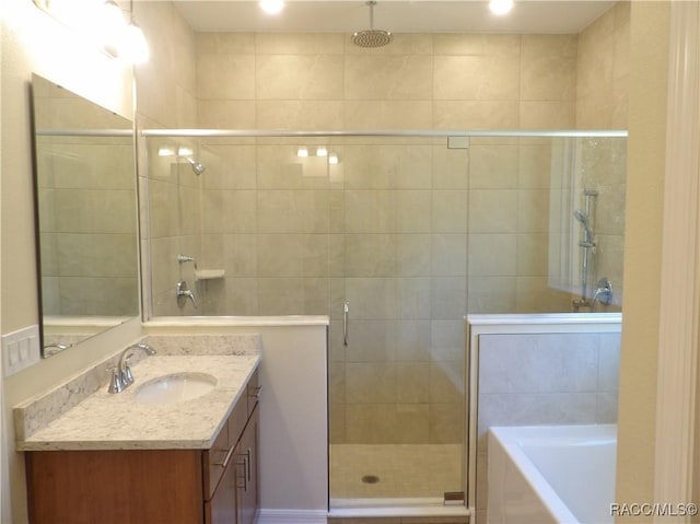 bathroom with vanity and separate shower and tub