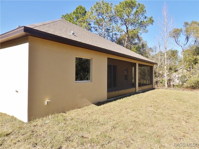 back of house with a yard and a sunroom