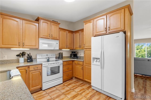 9 Flagler Dr, Palm Coast, FL 32137 - kitchen with white appliances, light tile patterned flooring, light brown cabinetry, and light stone counters