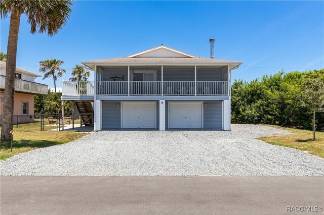9 Flagler Dr, Palm Coast, FL 32137 - raised beach house with stairway, gravel driveway, an attached garage, a shingled roof, and fence
