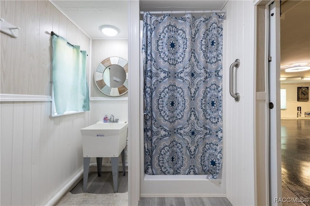 9 Flagler Dr, Palm Coast, FL 32137 - bathroom featuring a stall shower, wood finished floors, and wooden walls