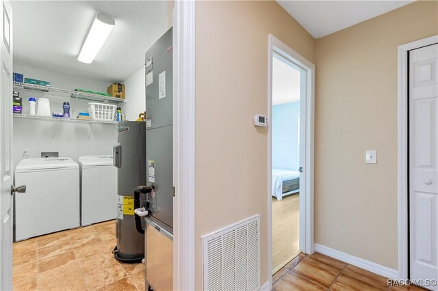 9 Flagler Dr, Palm Coast, FL 32137 - laundry room with washing machine and clothes dryer, water heater, and baseboards