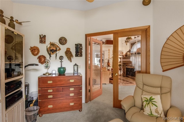 sitting room featuring light carpet and french doors