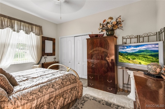 carpeted bedroom featuring ceiling fan and a closet