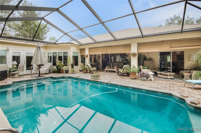 view of swimming pool featuring glass enclosure, a patio area, french doors, and an outdoor hangout area