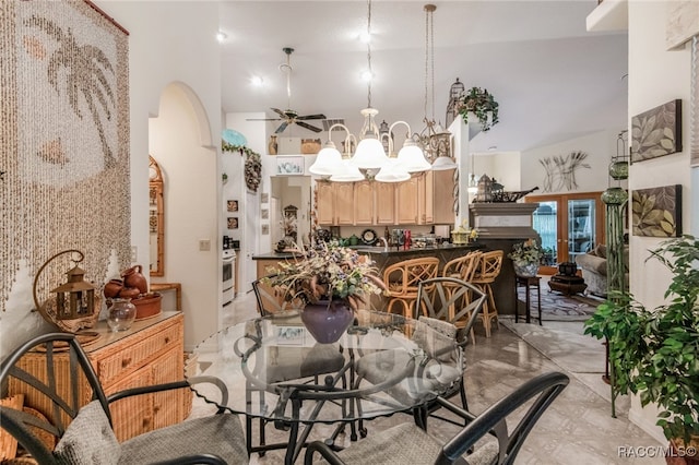 dining room featuring high vaulted ceiling and ceiling fan with notable chandelier