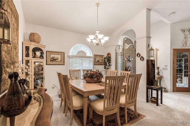 carpeted dining space with a chandelier