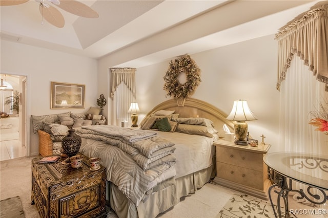 bedroom with ceiling fan, light carpet, and connected bathroom