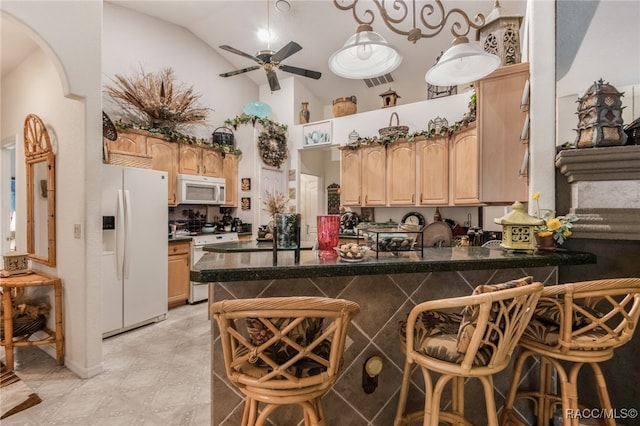 kitchen with ceiling fan, kitchen peninsula, lofted ceiling, white appliances, and a breakfast bar