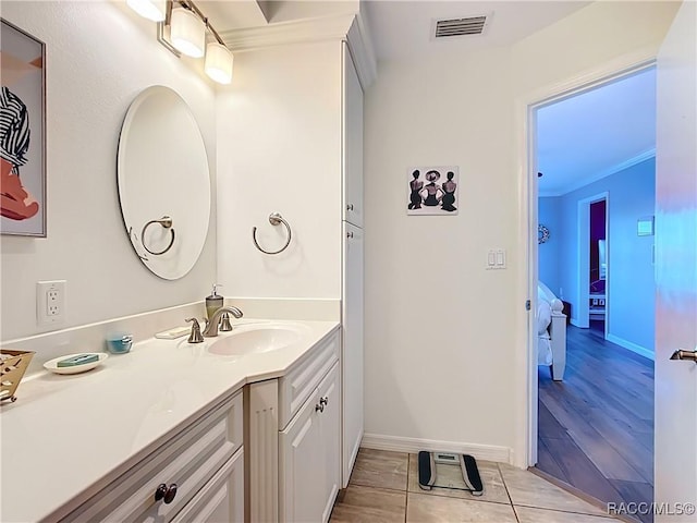 bathroom featuring tile patterned flooring, visible vents, connected bathroom, ornamental molding, and vanity