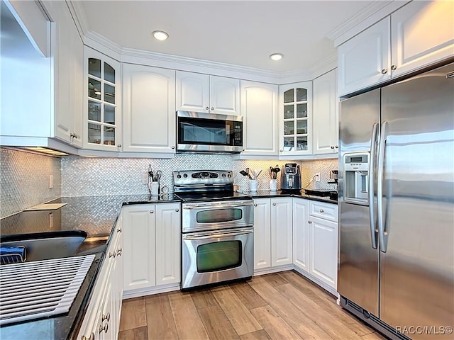 kitchen featuring glass insert cabinets, white cabinets, appliances with stainless steel finishes, and light wood-type flooring