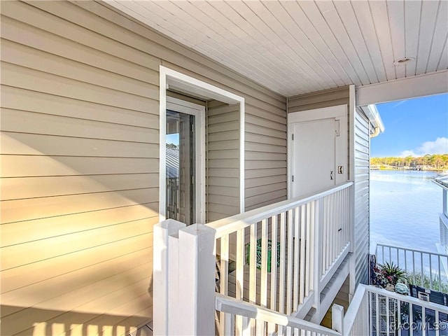 doorway to property with a balcony and a water view