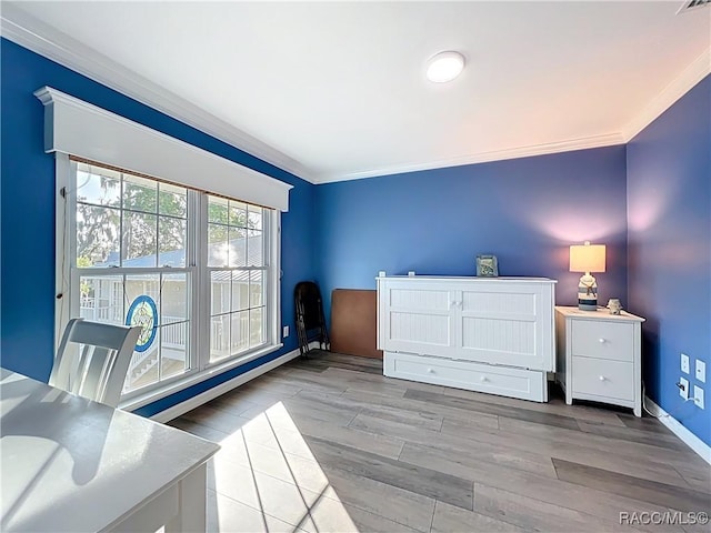 unfurnished bedroom featuring crown molding, baseboards, and wood finished floors