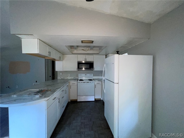 kitchen with kitchen peninsula, white appliances, and white cabinetry