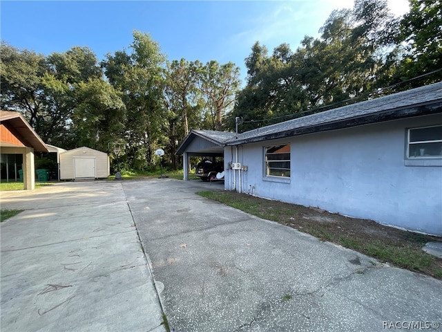 view of home's exterior featuring a storage unit and a carport