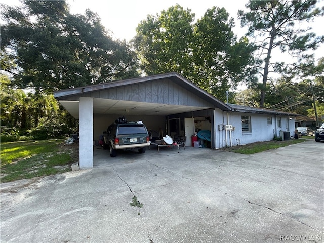 view of side of property featuring central AC unit and a carport